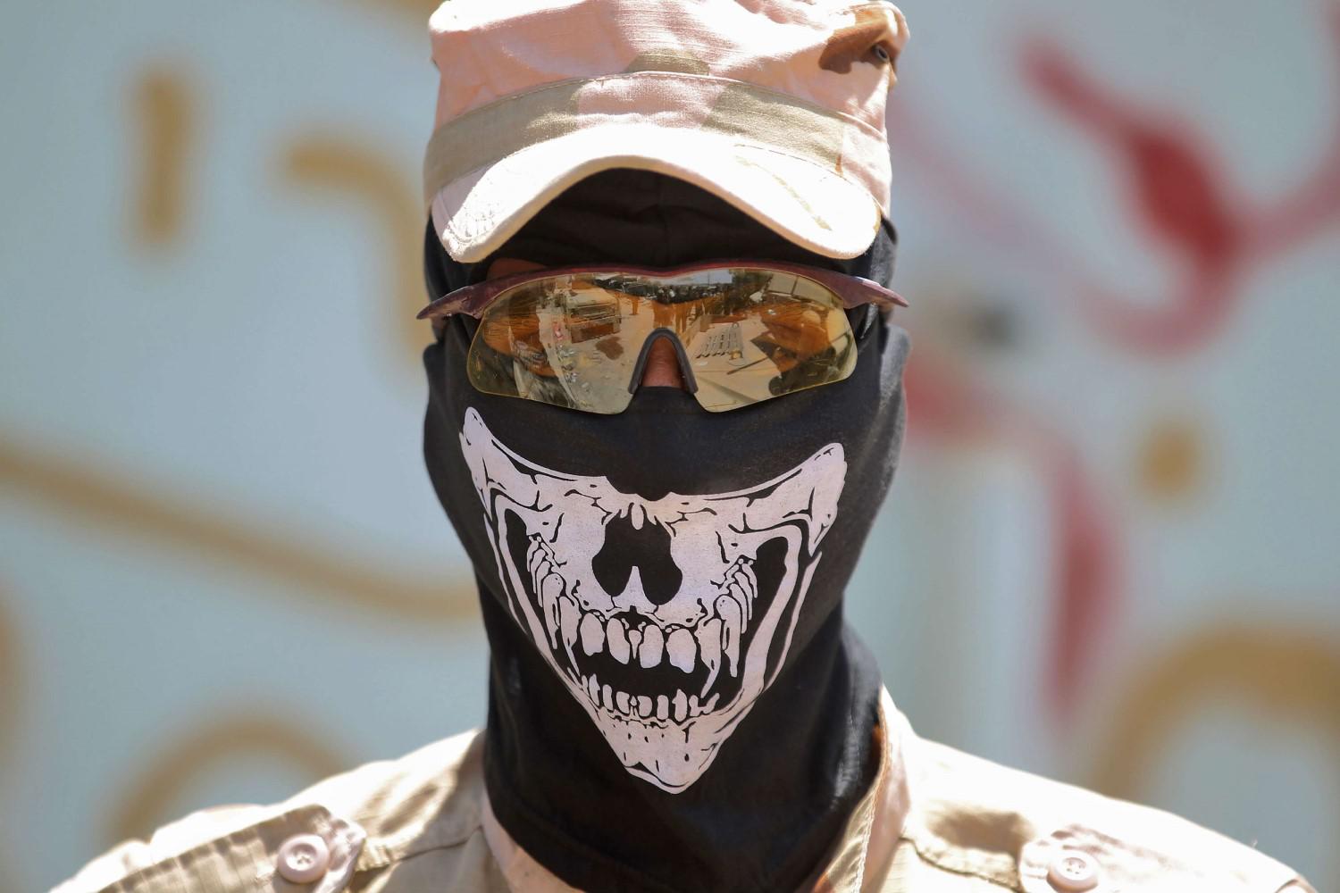 مسلح من الحشد الشعبي يرتدي قناعا