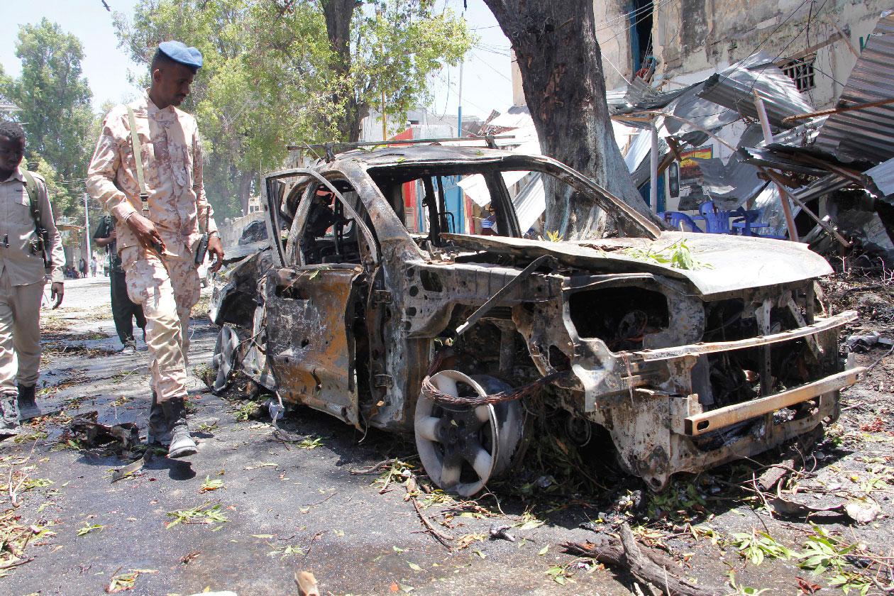 A Somali soldier walks near the wreckage of a car in Mogadishu, Somalia, Thursday March 7, 2019.
