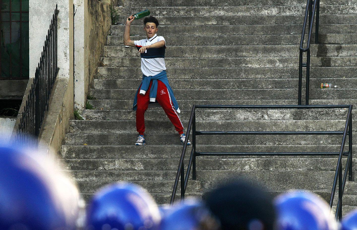 A demonstrator throw a bottle during clashes with police in Algiers, Algeria, March 29, 2019.