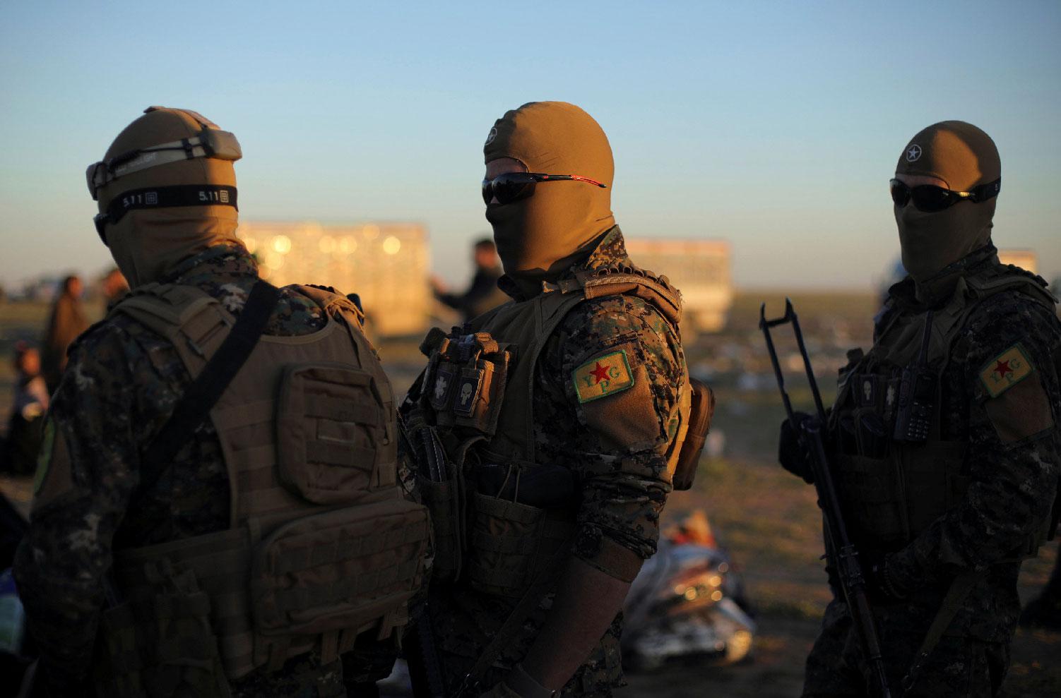 Fighters of Syrian Democratic Forces (SDF) stand together near the village of Baghouz, Deir Al Zor province, Syria March 1, 2019.