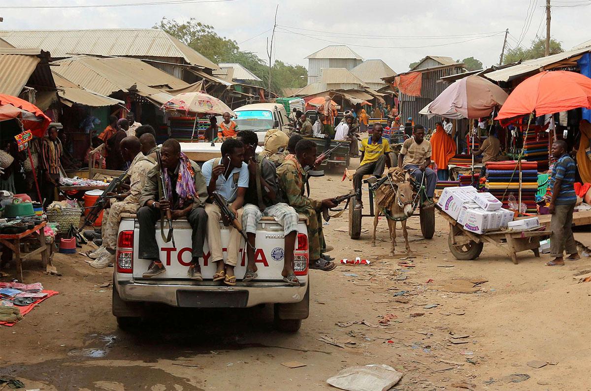 Somali soldiers patrol a street market in Afgoye