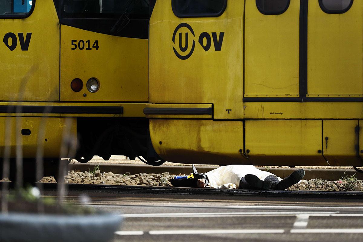 A body lying on the ground is covered near a tram at the 24 Oktoberplace in Utrecht