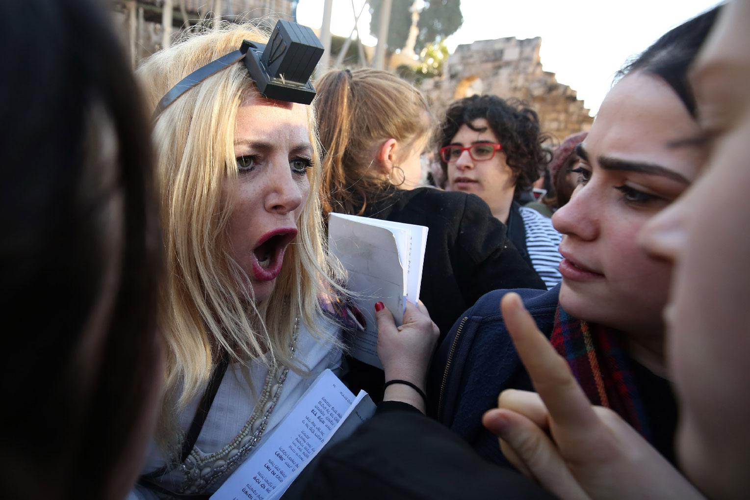 A member of the liberal Jewish religious movement "Women of the Wall" argues with Ultra Orthodox Jewish girls.
