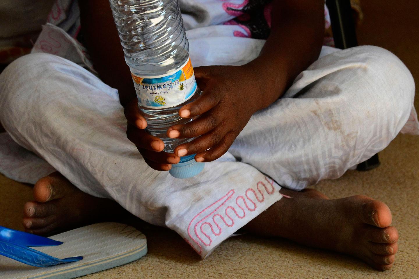 A picture shows the feet and hands of the daughter of Zahra (not her real name) in the office of the president of the Association of Women Heads of Family (AFCF) in Nouakchott on January 28, 2019.