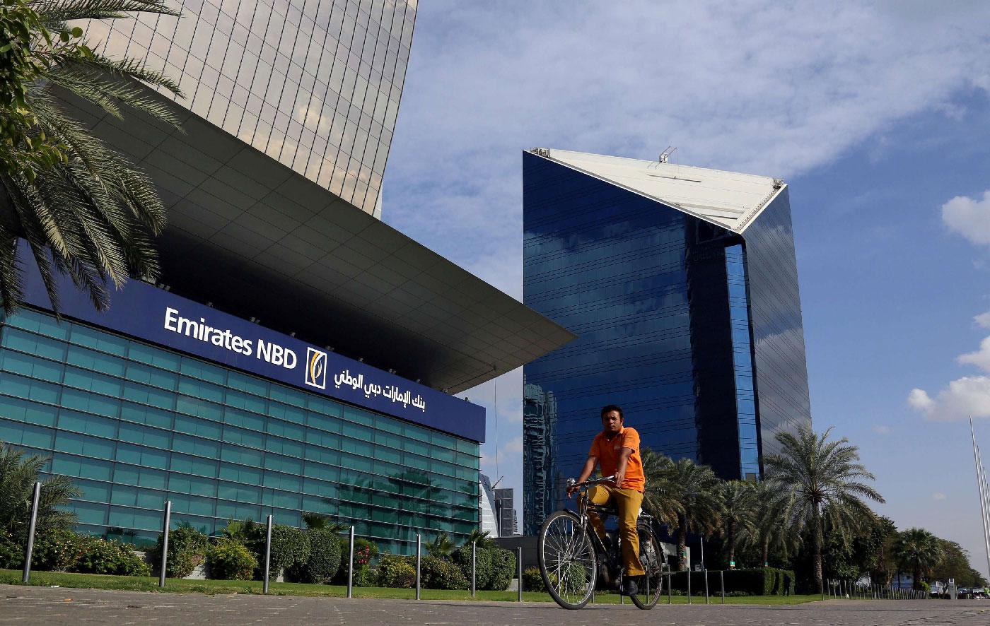 A man rides a bicycle past Emirates NBD head office in Dubai, UAE January 30, 2018.