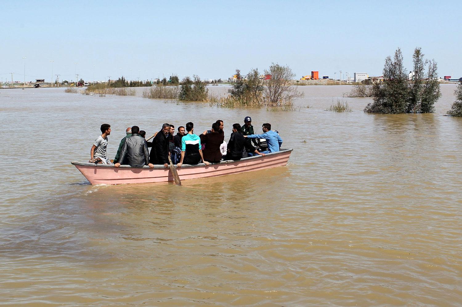 People are seen on a boat after a flooding in Golestan province, Iran, March 24, 2019.
