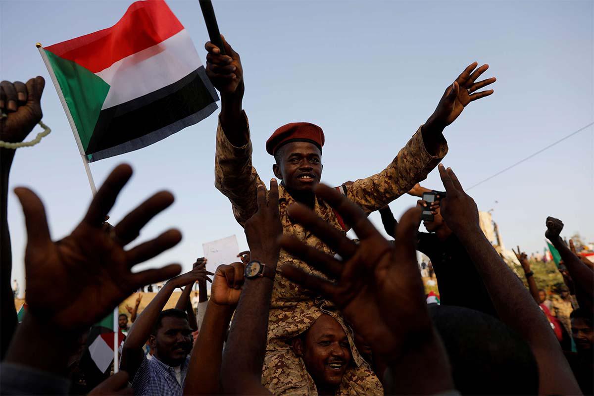 A Sudanese soldier sits on the shoulders of a protester in Khartoum