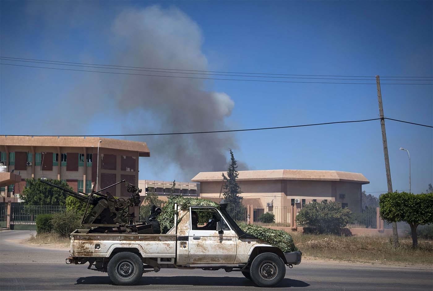 Smoke rises above buildings in Espiaa, south of Tripoli