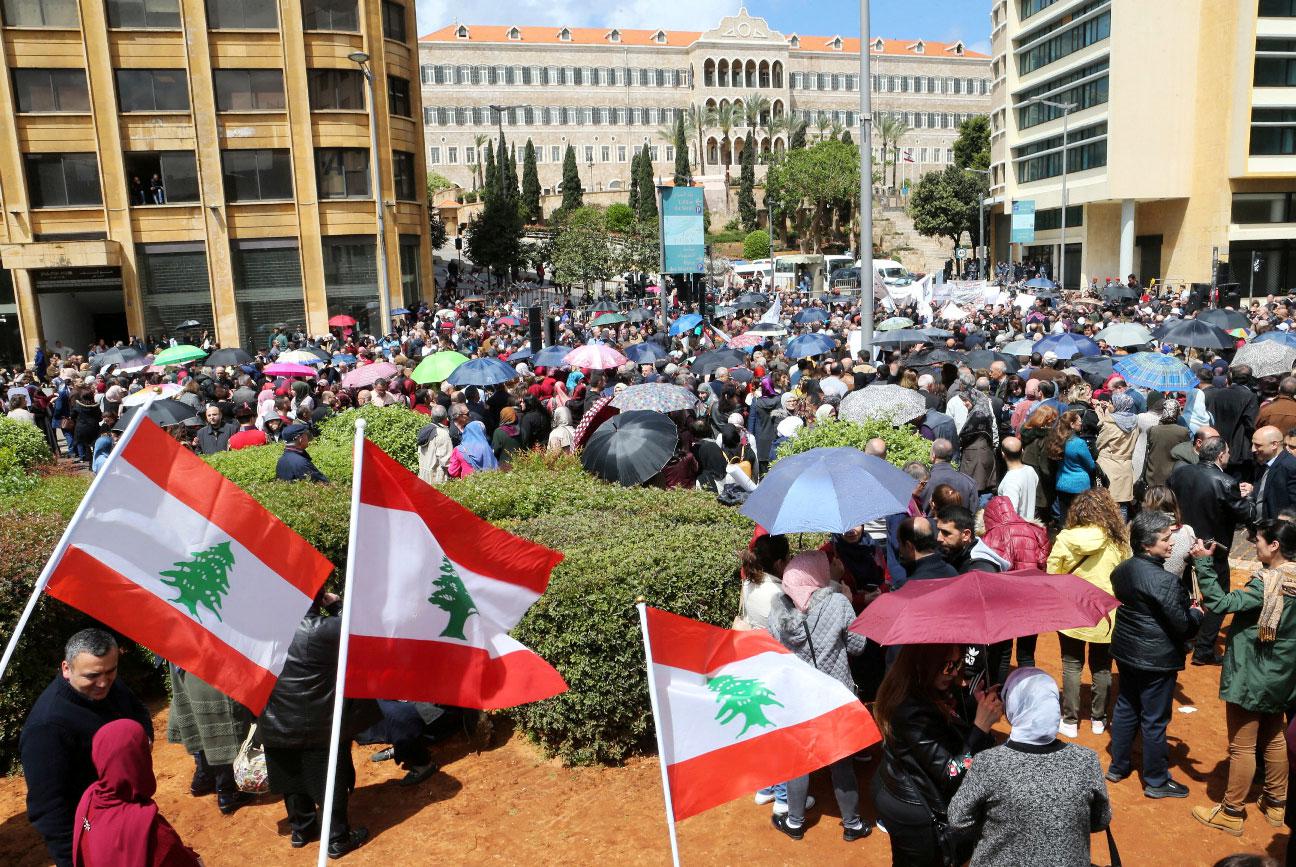 Public sector workers hold Lebanese flags during a protest in downtown Beirut