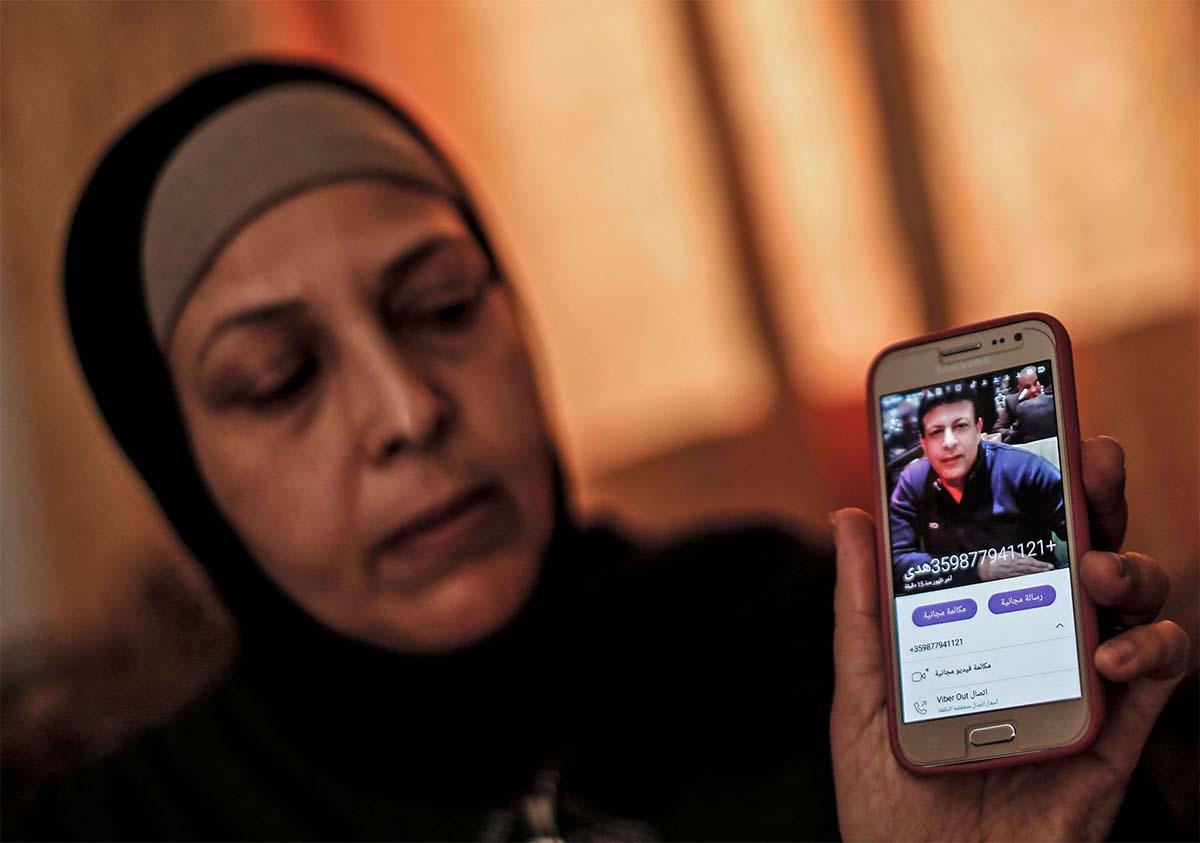 The sister of Zaki Mubarak shows his picture during an interview in their family home in Deir al-Balah