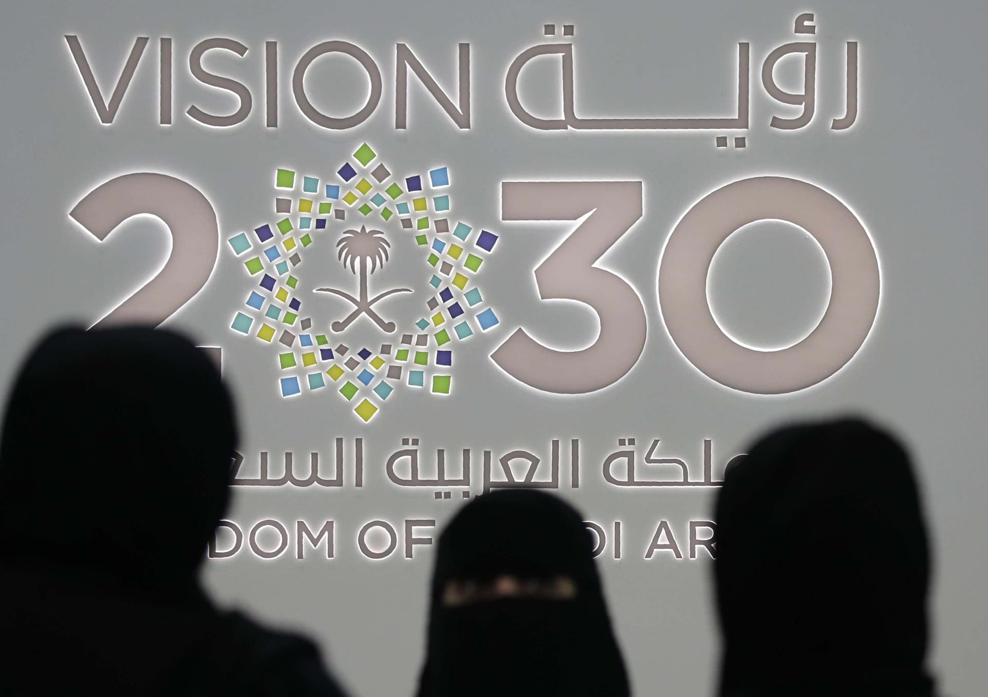  Saudi women stand next to the Saudi pavilion (Vision 2030) at the Gitex 2018 exhibition at the Dubai World Trade Centre in Dubai, October 16, 2018