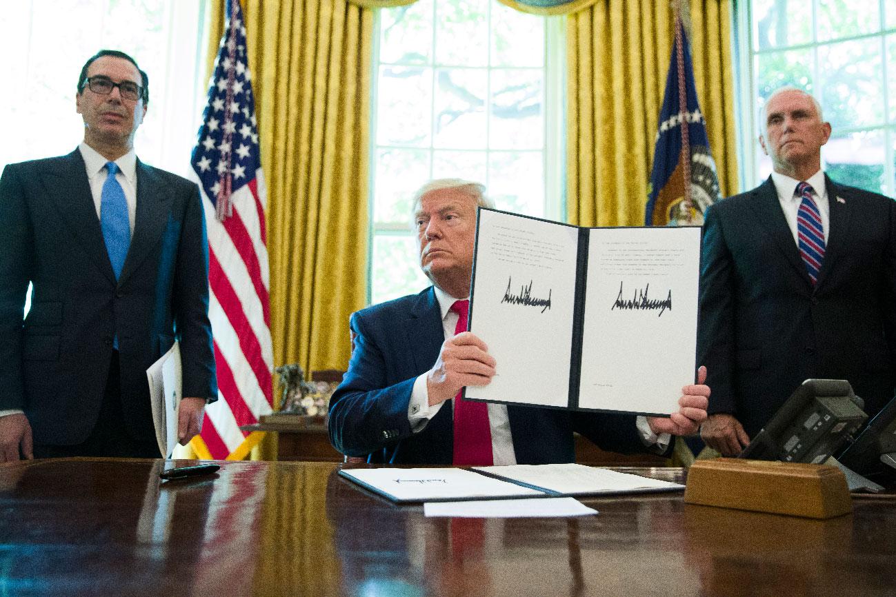 President Donald Trump holds up a signed executive order to increase sanctions on Iran