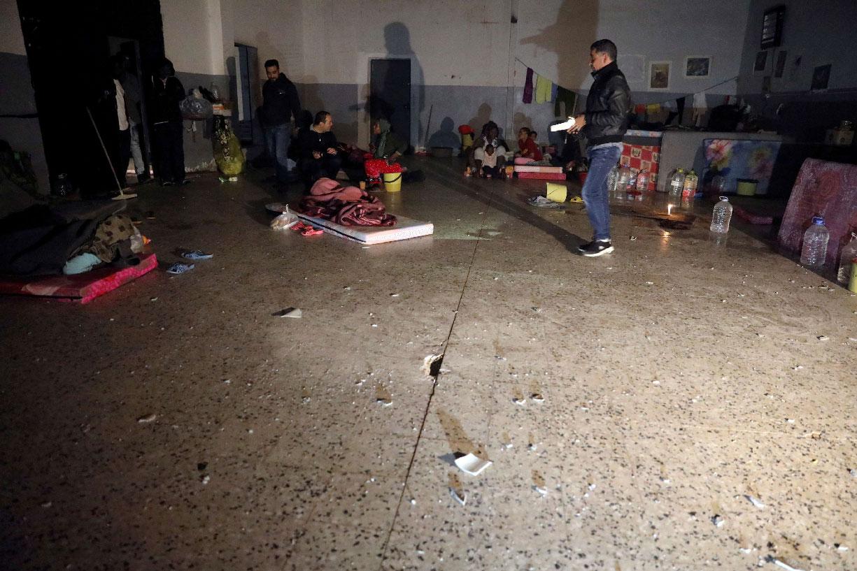 Migrants sit inside the Anti-Illegal Immigration Agency in Tajora shelter center, Tripoli