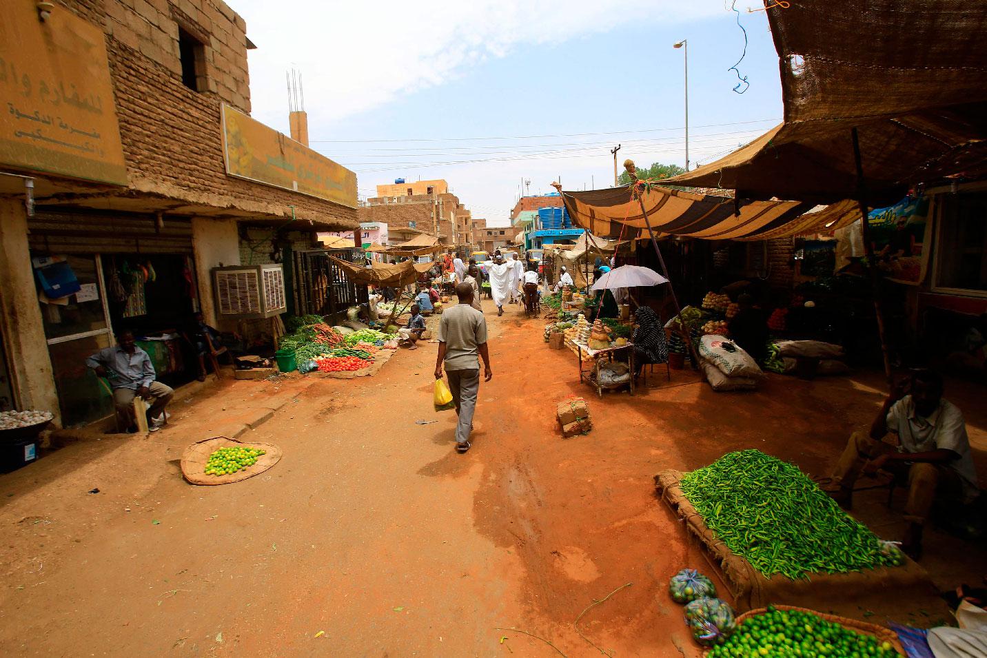 Sudanese residents walk in the central market of Khartoum