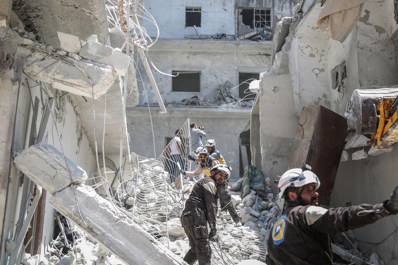 Members of the Syrian Civil Defence search for victims or survivors after an air strike