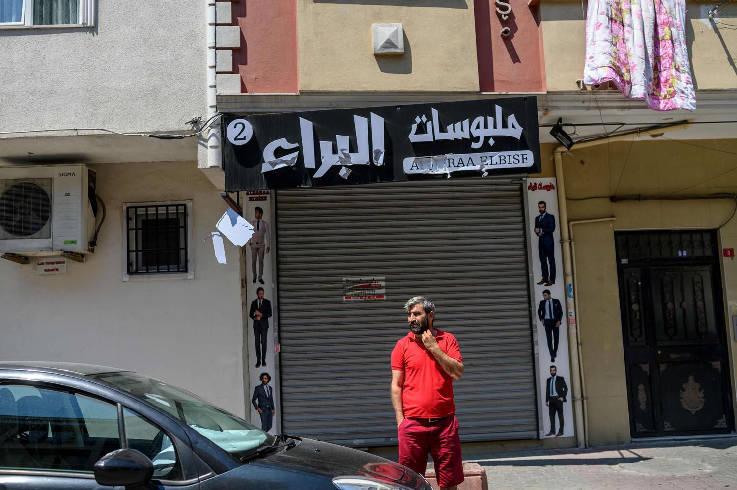 لاجئ سوري أمام محل تعرض للتخريب في اسطنبول