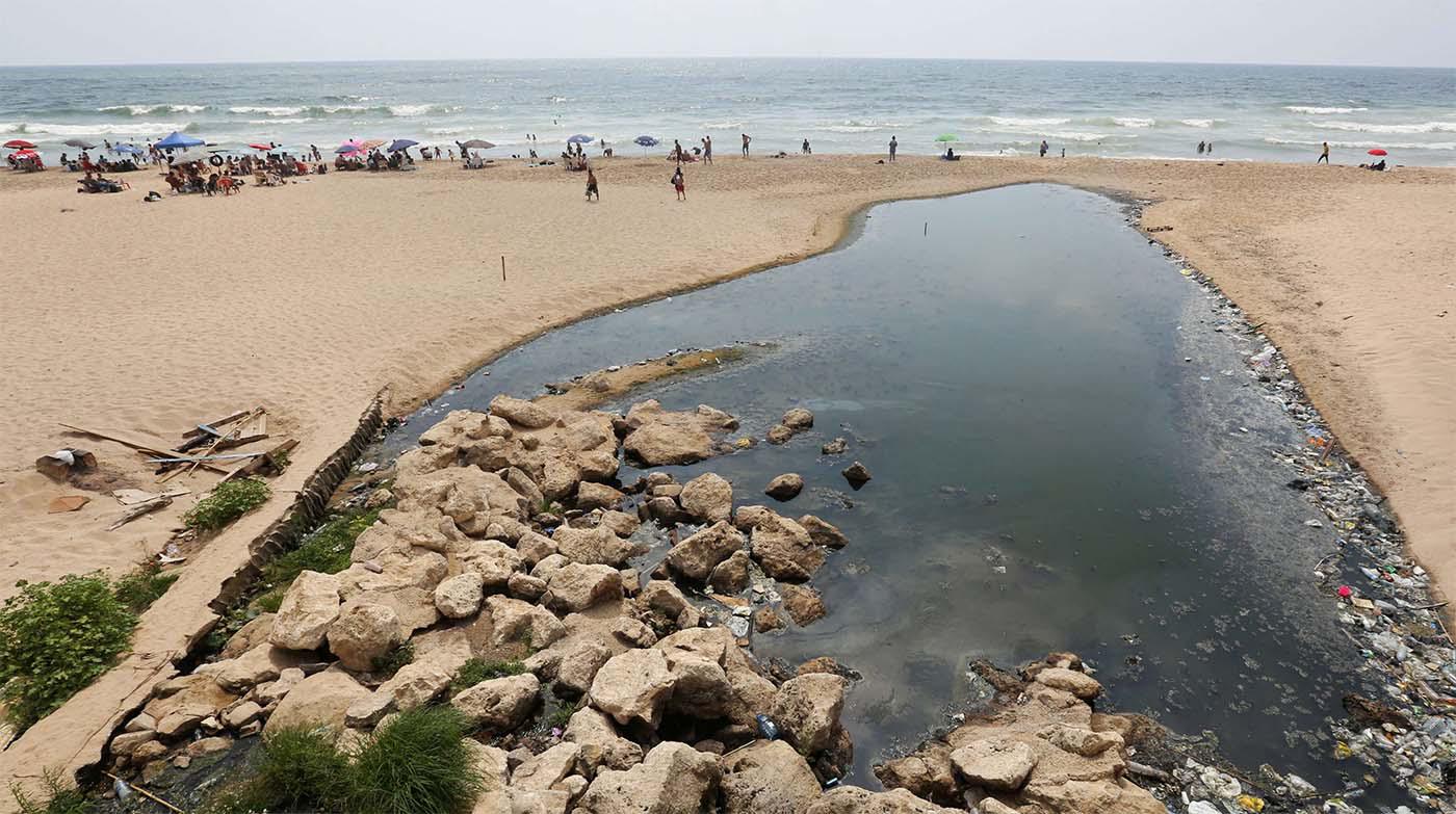 eople swim at Ramlet al-Bayda public beach near a sewage outlet in Beirut