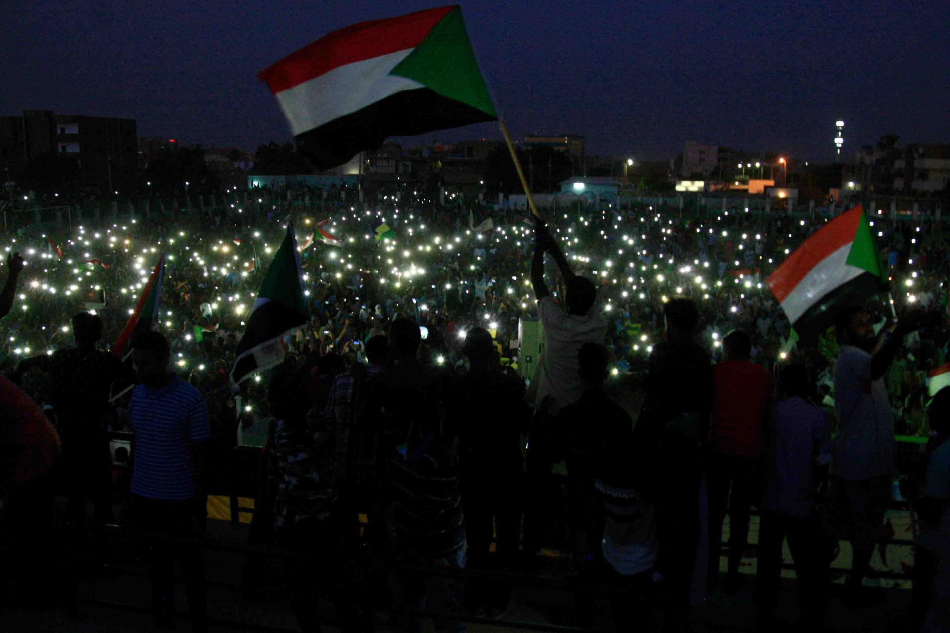 Groups of protesters sat in circles around Sudanese flags and candles in several neighbourhoods as the sun set over Khartoum.