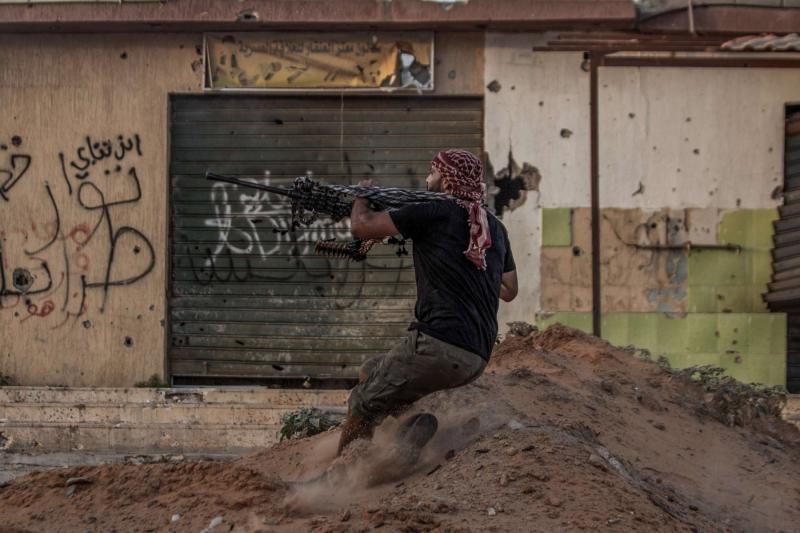 A fighter loyal to Libya's UN-backed Government of National Accord (GNA) fires his machine gun, at the Salah al-Din front line