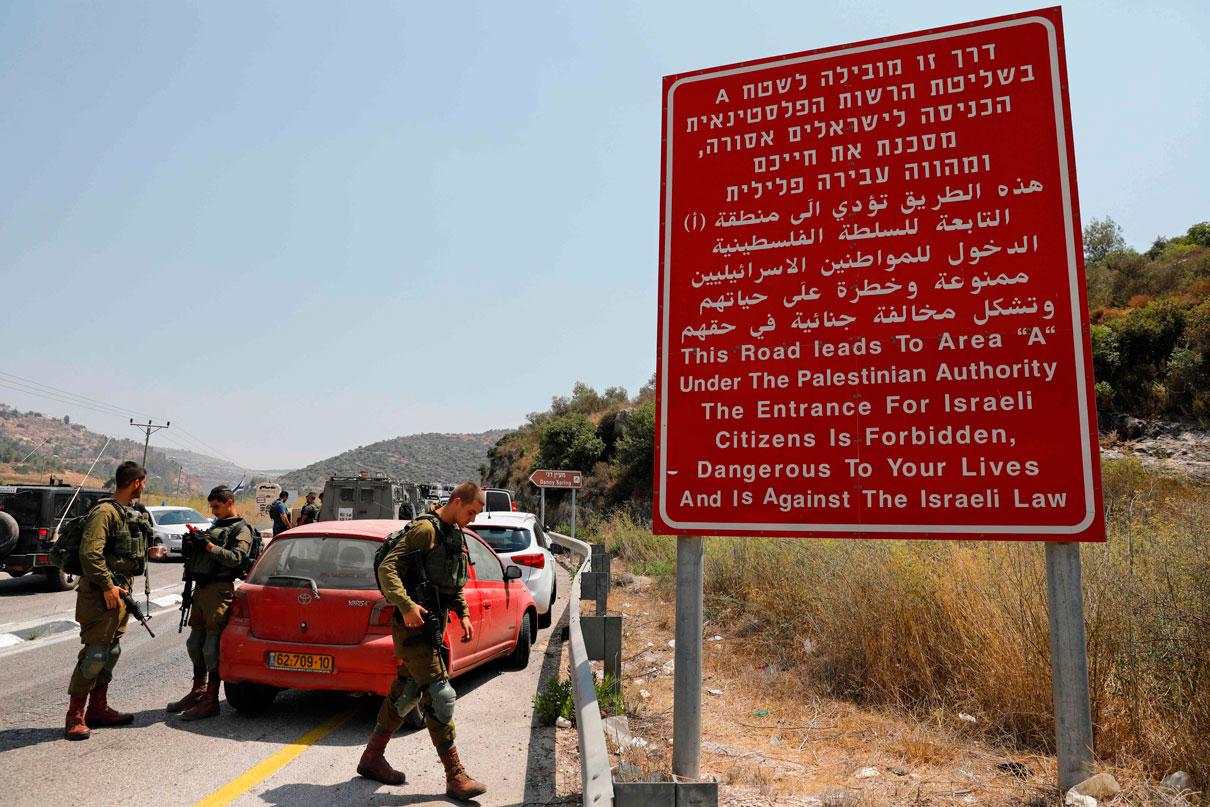 Israeli occupation forces gather at the site where a bomb exploded near the Jewish settlement of Dolev in the occupied West Bank