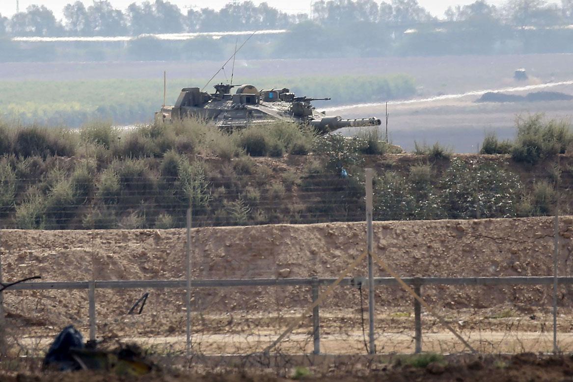 A picture taken from Khan Yunis shows an Israeli tank inspecting the area across the border fence with the southern Gaza Strip