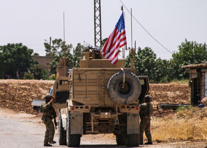 US soldiers climb into a vehicle of the US-led coalition as they prepare to leave the city of Ras al-Ain in Syria's Hasakeh province