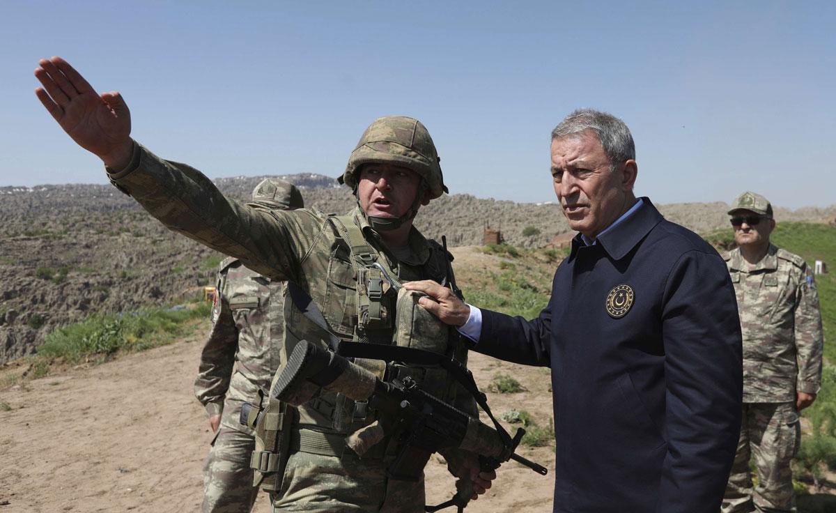 Defense Minister Hulusi Akar (R) speaks with a Turkish officer