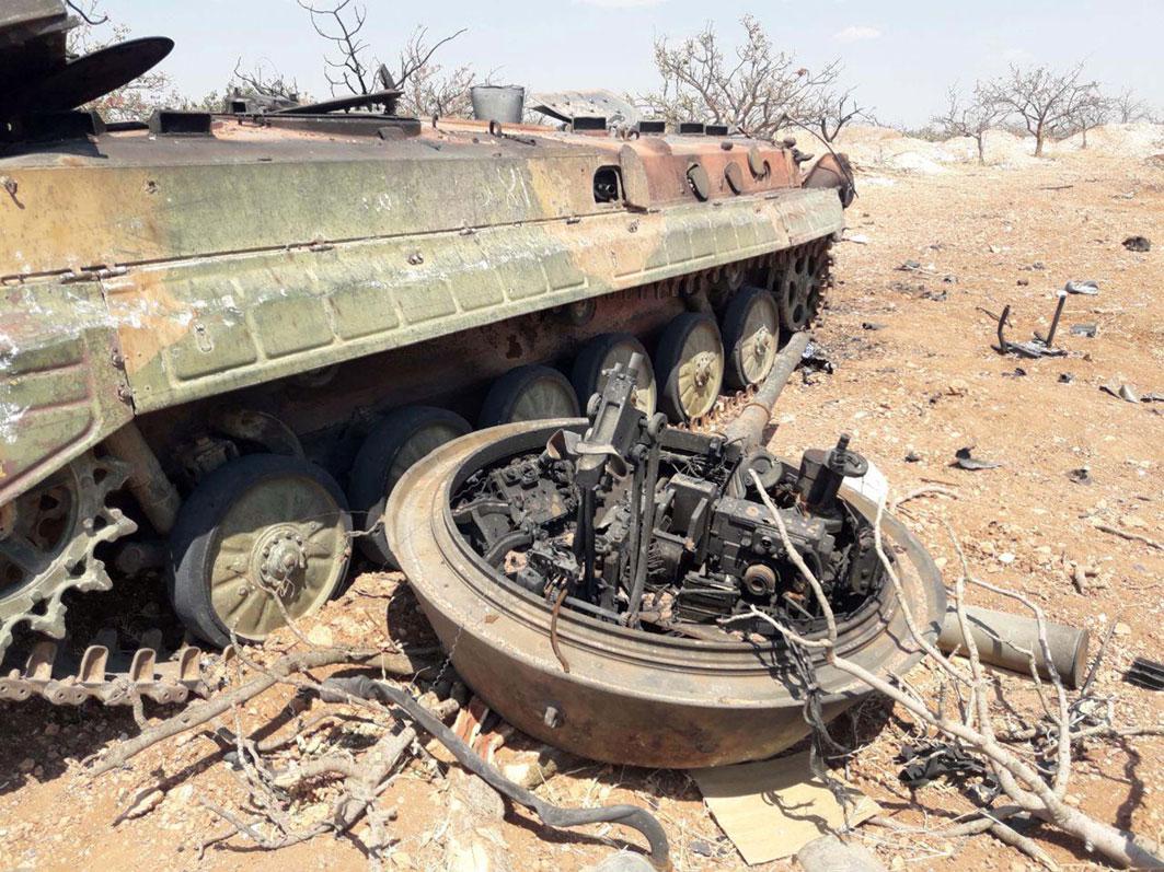 A damaged military tank is seen in Idlib countryside, Syria