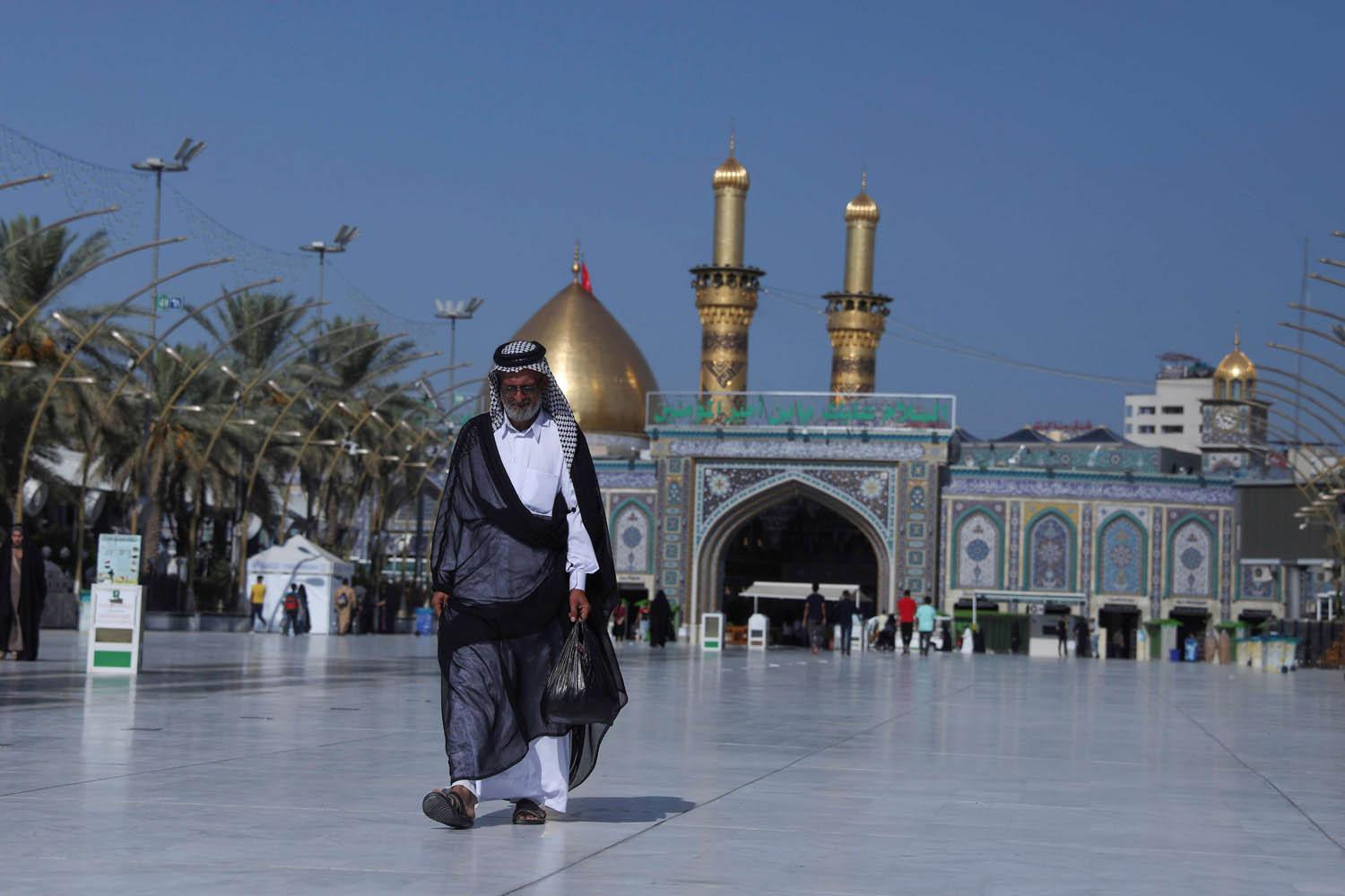 زائر أمام ضريح الإمام الحسين في كربلاء