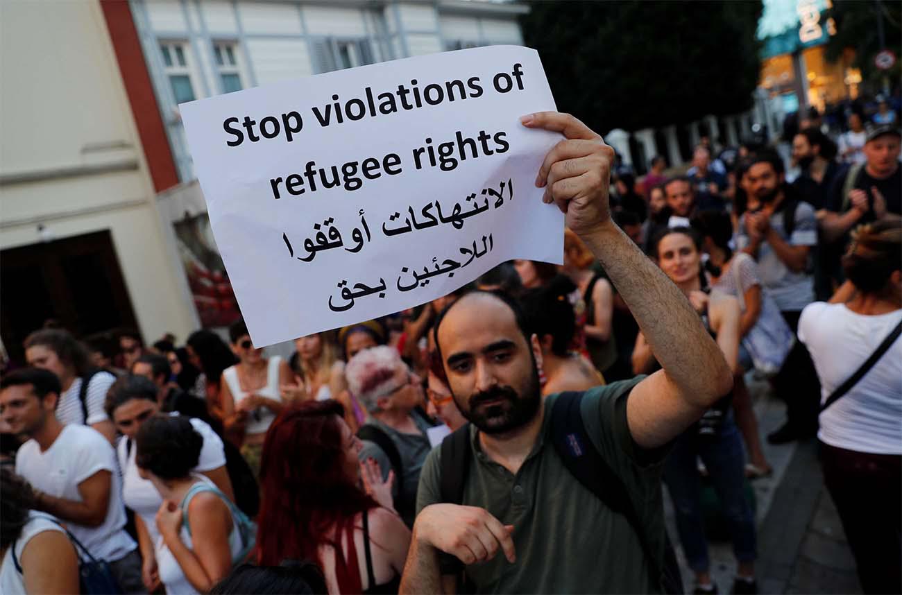 A demonstrator holds a placard during a protest against Turkish government's recent refugee policies in Istanbul