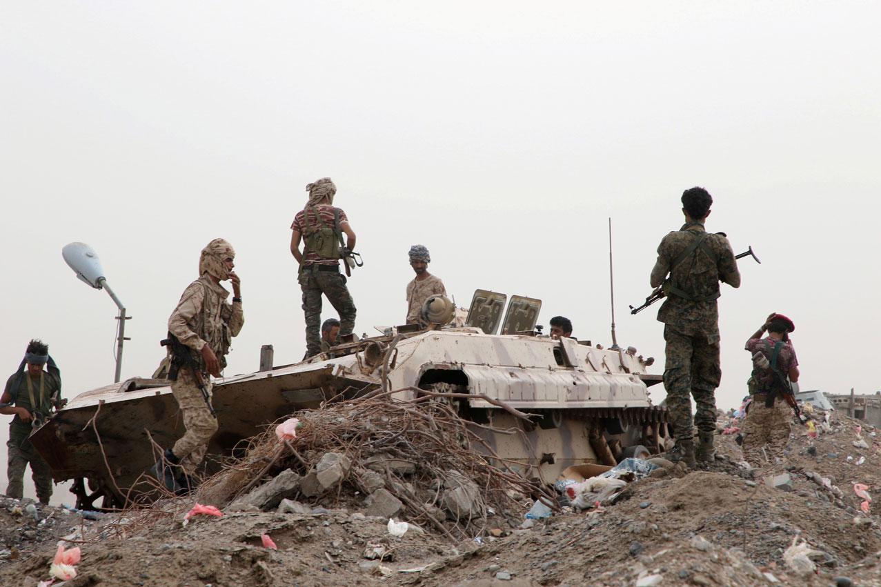 Members of STC military forces stand by a military vehicle during clashes with government forces in Aden