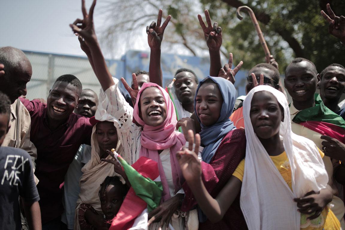 Sudanese men and women celebrate outside the Friendship Hall in the capital Khartoum