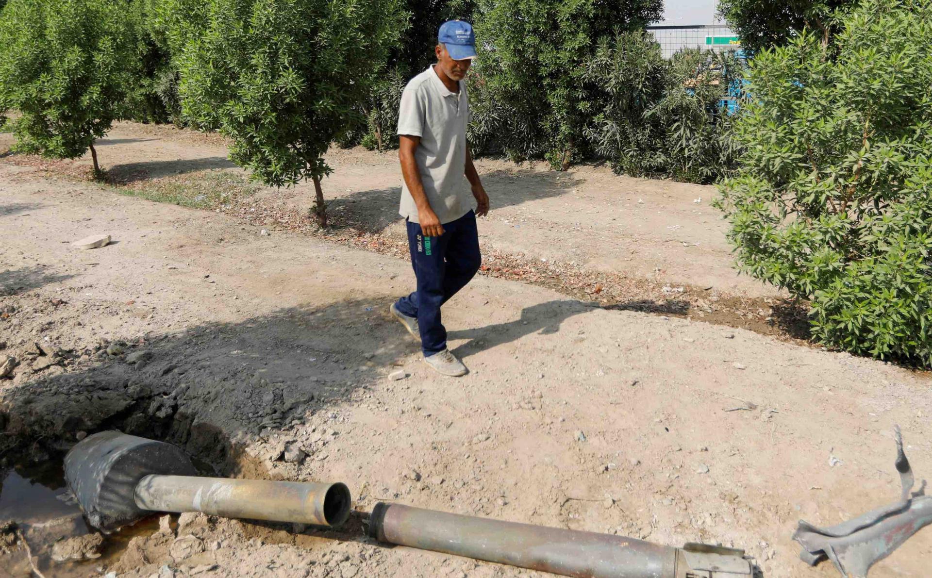 A man glances at a rocket that flew away from an Iraqi militia group's weapons depot after it caught fire, in Baghdad, Iraq