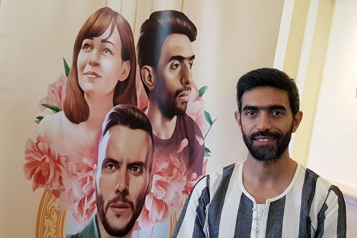 بطل الفيلم عمرو عابد يقف بجانب الملصق الدعائي لفيلمه في مهرجان الجونة السينمائي