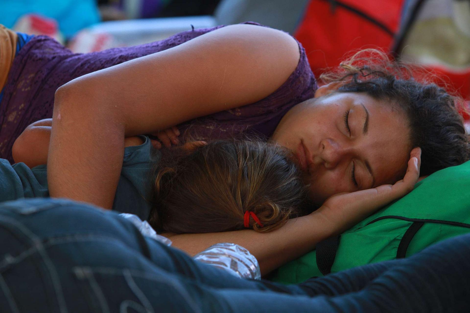 امرأة نائمة بجانب طفلها