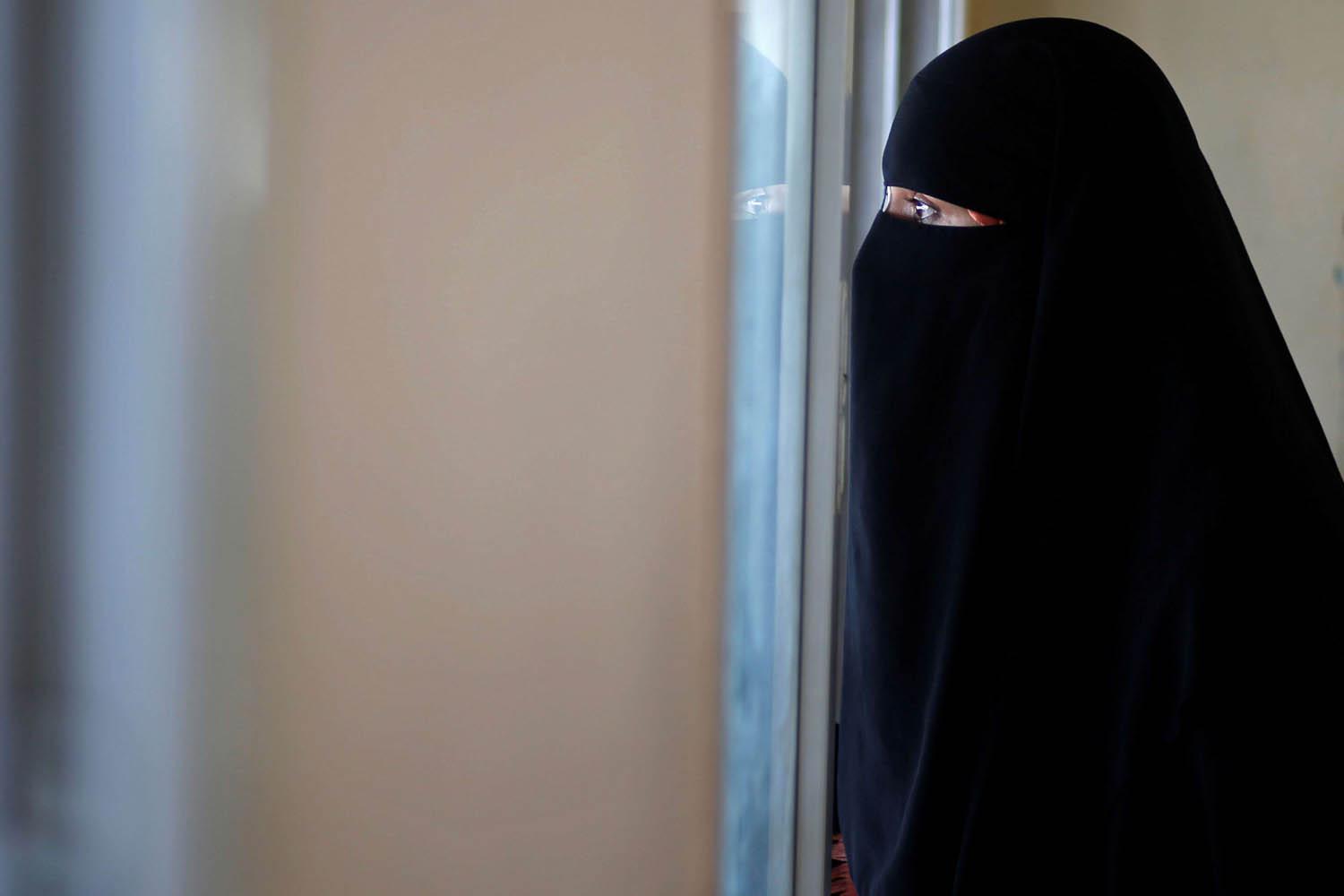 فلسطينية تنظر من الشباك عند معبر رفح في غزة