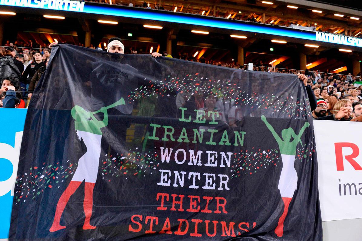 Iranian football supporters hold a banner reading 'let Iranian women enter their stadiums' 