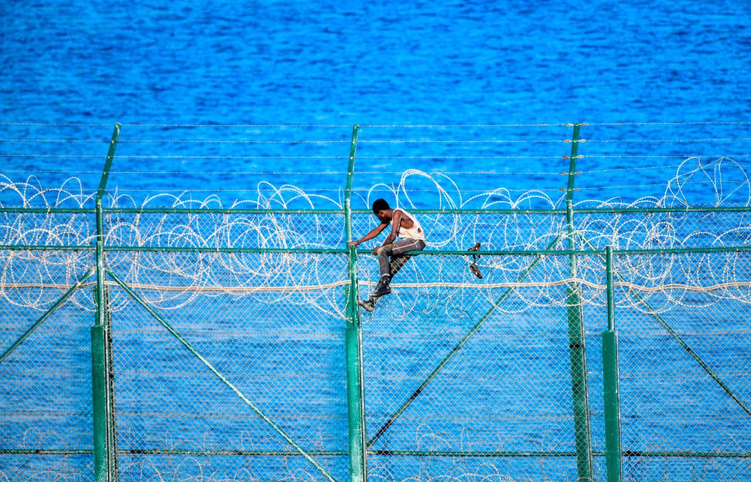 A migrant forces his way into the Spanish territory of Ceuta