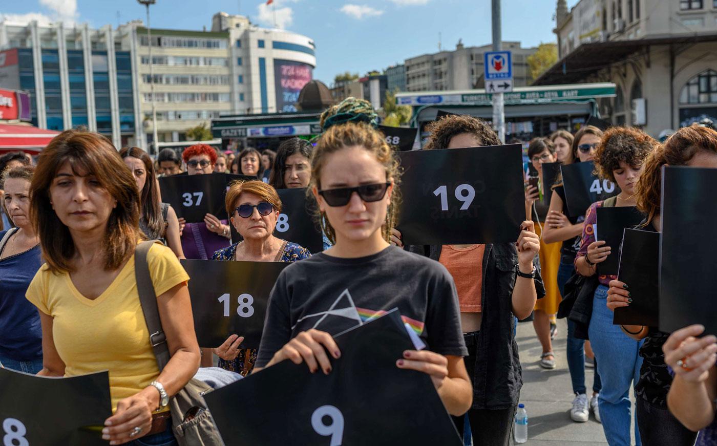 hold signs with different numbers symbolizing the women murders during a protest against gender violence in Istanbul