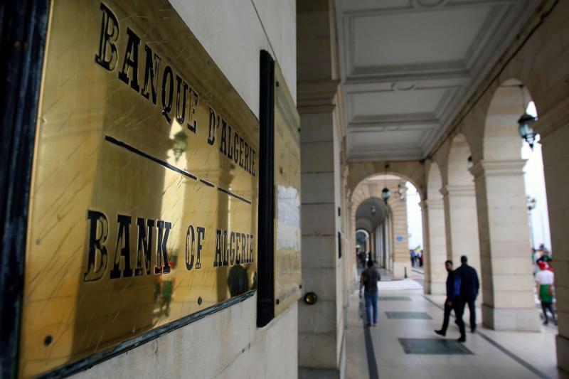 People walk past the headquarters of the Bank of Algeria in Algiers