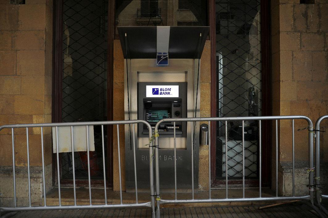 Metal barriers are set in front of an ATM at a closed Blom Bank branch in downtown Beirut
