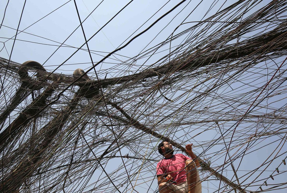 An Iraqi man checks electrical wires in Baghdad