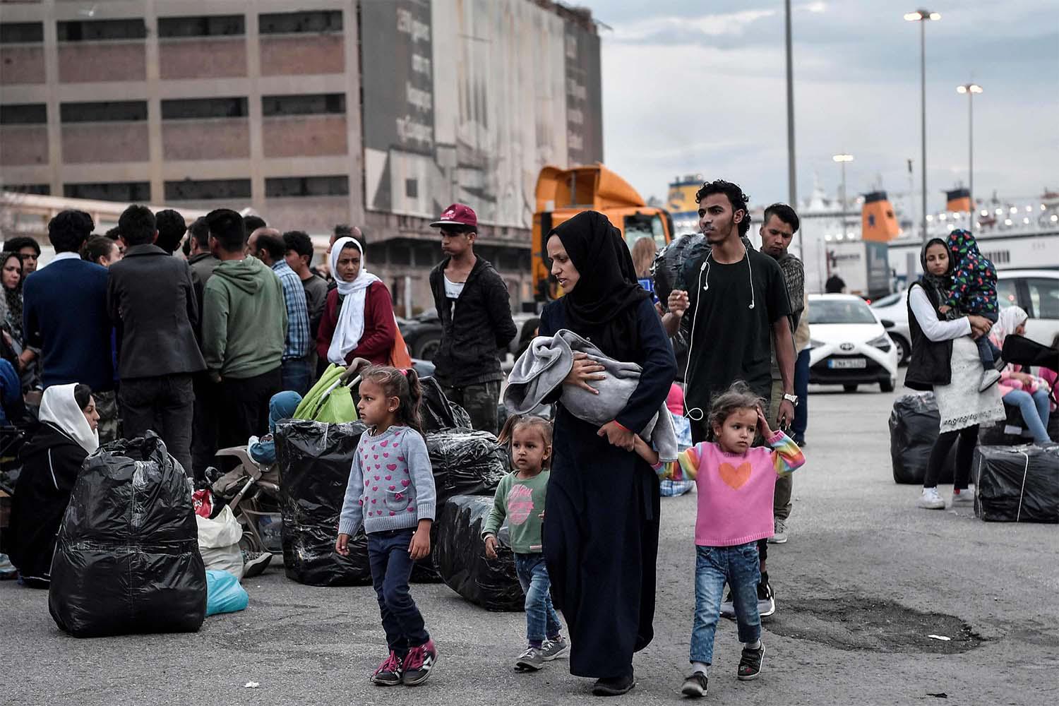 Refugees and migrants wait to be transferred to a camp in northern Greece, after their arrival from the island of Lesbos to the port of Piraeus near Athens