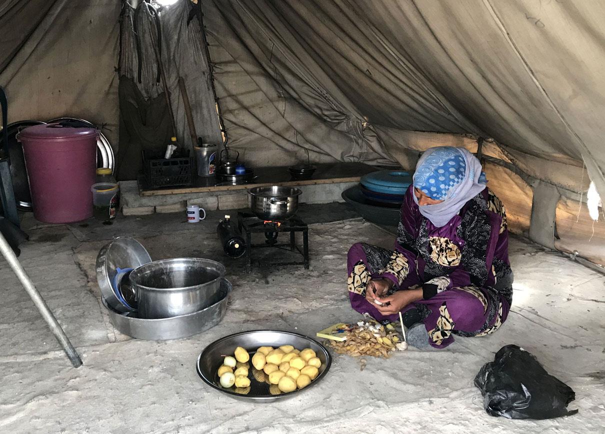 A woman prepares food in the Mabrouka camp, near Ras al-Ain, Syria