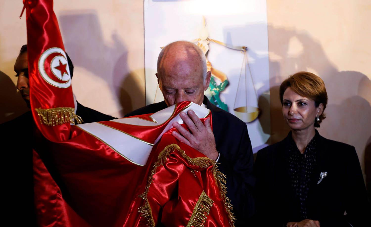 المرشح الرئاسي الفائز قيس سعيد يقبل علم بلاده