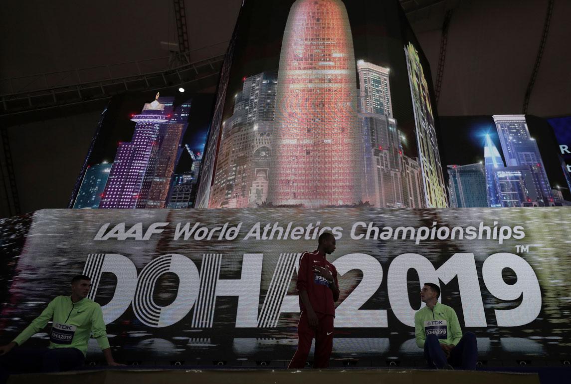 Athletes speak on the podium after the medal ceremony for the the men's high jump final was postponed