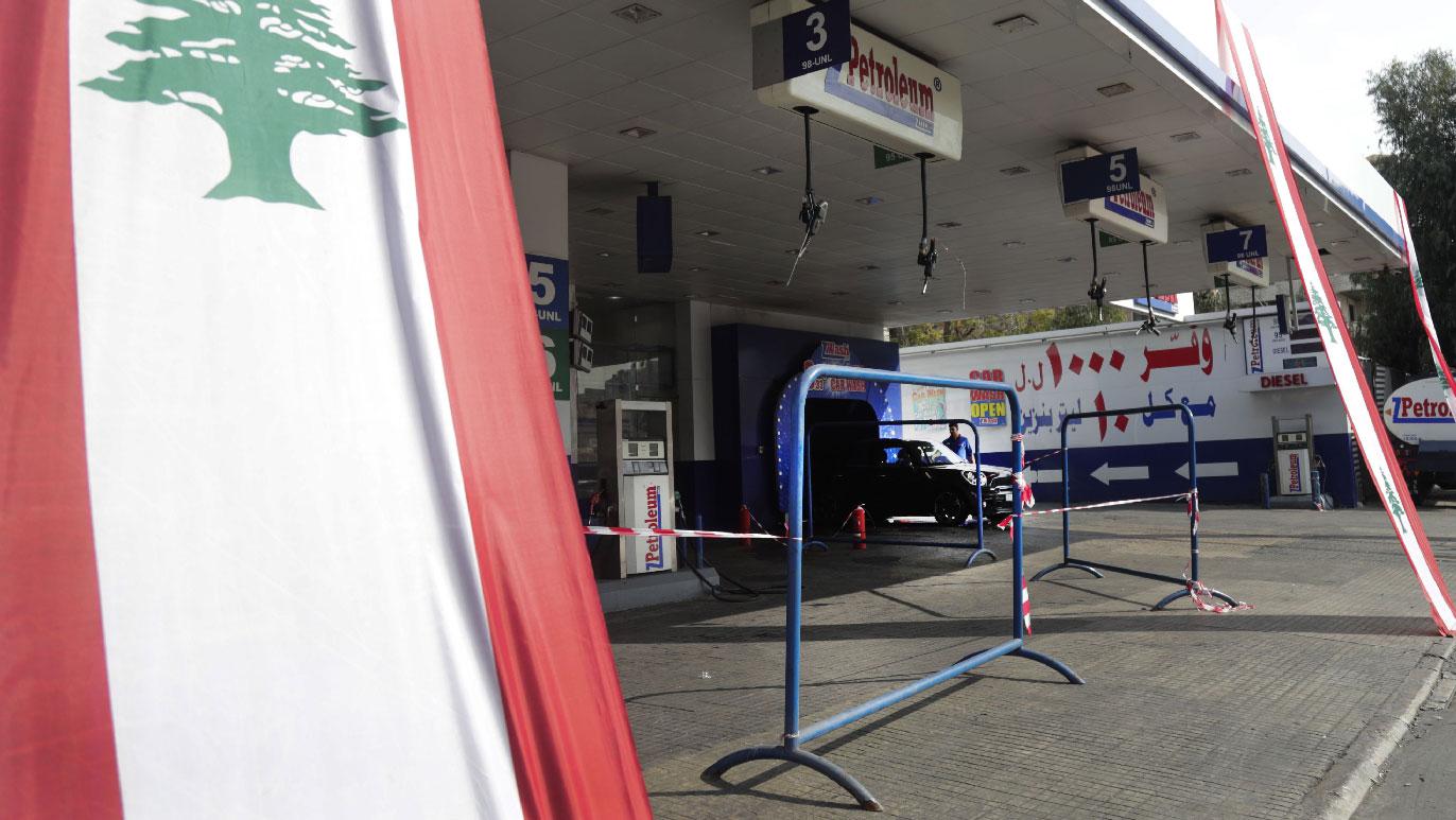 A Lebanese national flag hangs in front of a closed petrol station in the capital Beirut on November 9, 2019