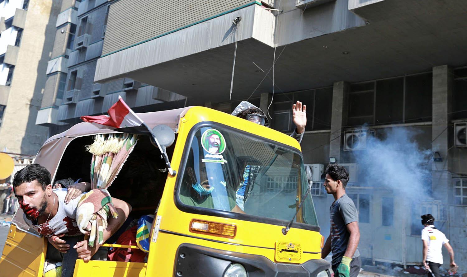 توك توك عراقي يخلي جريحا اثناء التظاهرات في بغداد