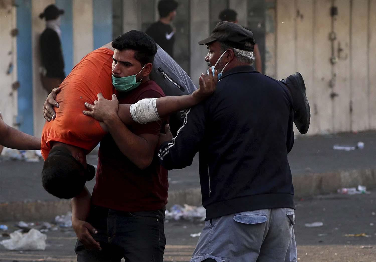 An injured protester is rushed to a hospital during clashes between Iraqi security forces and anti-government protesters in downtown Baghdad