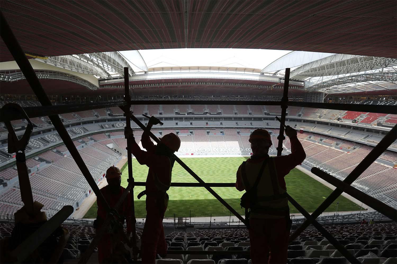 Workers remove scaffolding at the Al Bayt stadium in Al Khor, Qatar